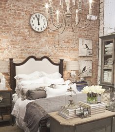 a bed room with a neatly made bed next to a dresser and a clock on the wall