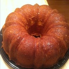 a bundt cake sitting on top of a black plate next to a wooden table