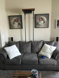 a living room filled with furniture and two pictures on the wall above it's coffee table