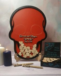 a red skull with white flowers on it next to two candles and some other items