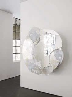 a white wall with a mirror hanging on it's side