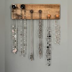 a wall mounted jewelry rack with lots of necklaces hanging from it's sides