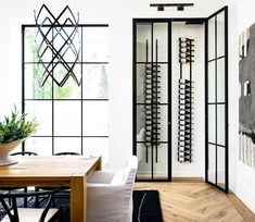 a dining room table and chairs with wine racks on the wall