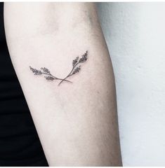 a small branch tattoo on the left arm