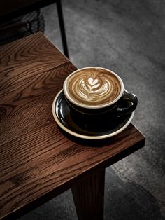 a cappuccino sitting on top of a wooden table