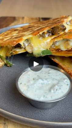 quesadilla cut in half on a plate with a small bowl of ranch dressing