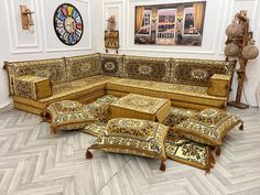 an elaborately designed couch and ottoman in a room with wood flooring, white walls and large clock on the wall