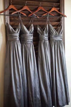 four bridesmaid dresses hanging on a rack