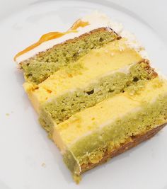 a piece of cake on a plate with white frosting and green icing, sitting on a table