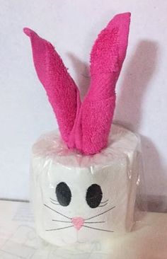 a white toilet paper roll with pink bunny ears on it's head and eyes