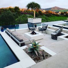 an outdoor living area with couches, chairs and a fire pit in the middle