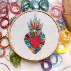 an embroidered heart surrounded by various colored threads