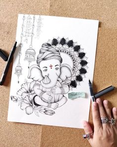 a drawing of an elephant is being drawn by someone's hand on the table