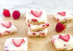 strawberries and cream squares are arranged on top of parchment paper, ready to be eaten