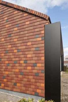 a brick building with a black metal sculpture next to it