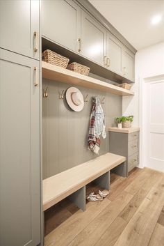 a wooden bench sitting in the middle of a room next to a wall mounted oven