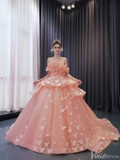 a woman in a pink ball gown standing next to a window with butterflies on it