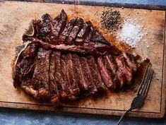 the steak has been sliced and ready to be eaten with a fork, salt and pepper sprinkled on top