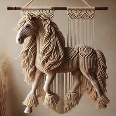 a horse made out of yarn hanging from a wall