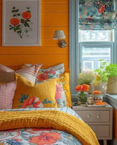 a bedroom with orange walls and yellow bedding, flowers on the window sill