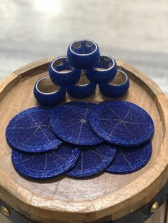 a wooden tray with six blue plates on top of it and five smaller ones in the middle