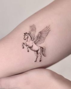 a woman's arm with a tattoo of a winged horse