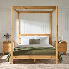 a wooden bed with white sheets and pillows