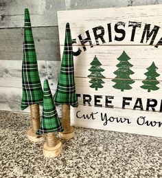 two christmas trees are sitting next to a sign that says, christmas tree farm cut your own