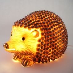 a hedgehog lamp sitting on top of a white table next to a light bulb