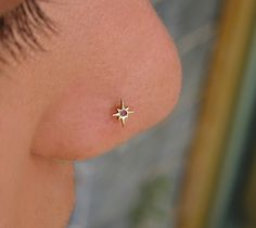 a woman's nose with a small star piercing on it