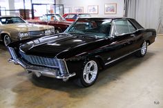 an old black car is parked in a garage