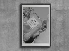 a black and white photo hanging on the wall with a bottle in front of it