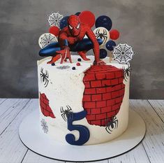 a spiderman birthday cake on a white plate