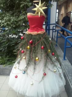 a christmas tree made out of tulle with decorations on the top and around it