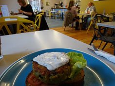 a blue plate topped with a burger covered in lettuce and tomato