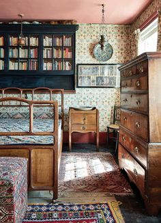 a bedroom with a bed, dresser and bookshelf