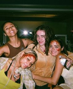 four young women are posing for the camera with makeup on their faces and hair in braids