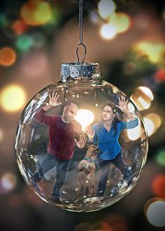 an ornament with two people and a dog hanging from it