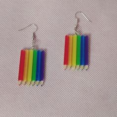 a pair of earrings made out of popsicle sticks