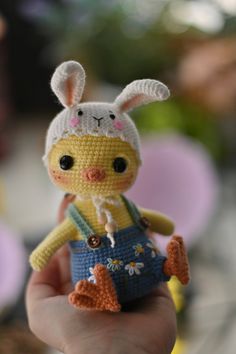 a small crocheted bunny doll is held in the palm of someone's hand