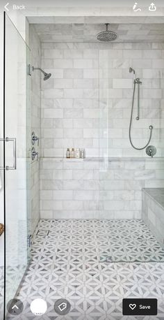 a white tiled bathroom with glass shower doors and tile flooring, along with a walk - in shower