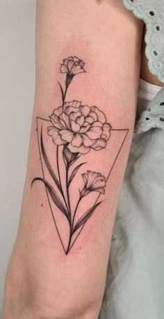 a black and white flower tattoo on the right arm with geometric shapes in the background