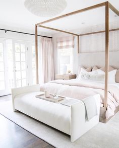 a bedroom with a canopy bed and white furniture