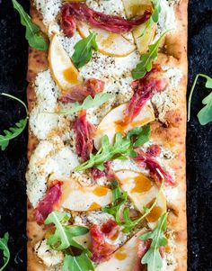 an apple and goat cheese flatbread on a black surface with text overlay that reads the food joy