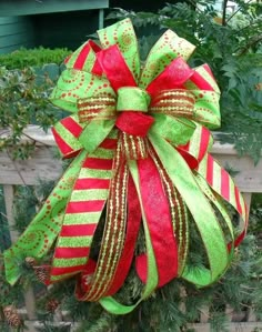 a green and red bow on top of a tree