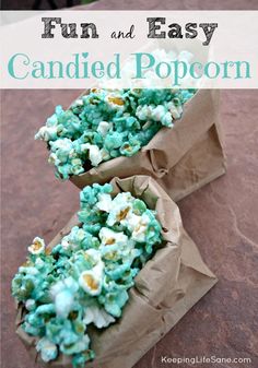 two paper bags filled with popcorn sitting on top of a brown table covered in blue and white sprinkles