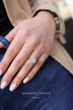 a woman's hand with a ring on her finger, holding onto the jeans