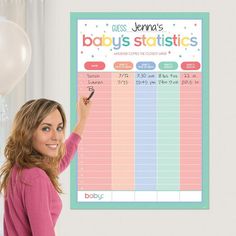 a woman standing in front of a baby's statistics board with balloons behind her