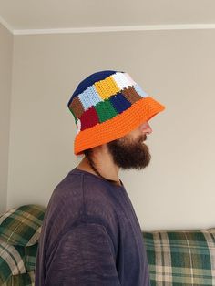 a man with a beard wearing a multicolored knitted hat on top of his head