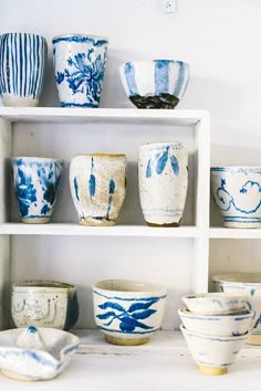 blue and white bowls sitting on shelves in a room